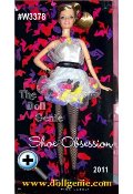 The 2012 Shoe Obsession Barbie Doll #W3378 is a true fashionista. Barbie can never have enough shoes. This whimsical dress celebrates that fashion heritage with 50 shoes sewn into its structure. A tulle overlay is gathered into pockets to hold classic Barbie mules in yellow, purple, black and pink (of course!). The pale gray dress is complemented by black fishnets and a cute pair of black ankle boots for a fun and fanciful look. A necklace with matching shoe icons completes the outfit while making a statement about Barbie dolls love of shoes - they are her favorite fashion accessory! 